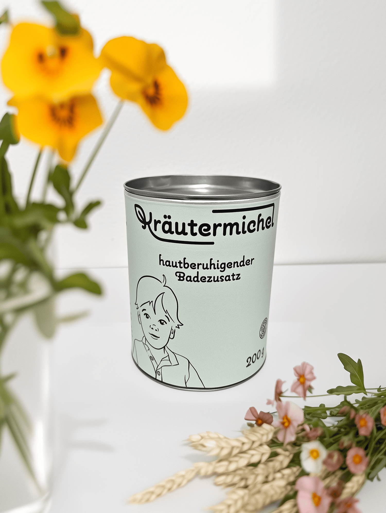 Die vollständig recyclebare Papierdose unseres Badezusatzes, mit silbernem Deckel, platziert auf einem weißen Tisch.